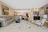 Open-concept living space featuring large format tile flooring, recessed lighting, and a built-in wet bar with cabinetry, stone countertop