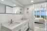 Open-concept living space featuring exposed concrete ceilings, polished stone flooring, custom wall-mounted cabinetry, track lighting, and floor-to-ce