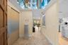 Entryway featuring a beautiful decorative light, recessed lighting, sliding panel doors, and neutral-toned tile flooring