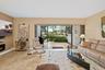 Open-concept room featuring an electric fireplace, large-format tile flooring, and retractable sliding glass doors opening to a screened lanai