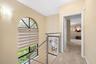Arched window featuring a multi-pane design, complemented by a contemporary stainless steel cable railing system and wall-mounted sconce lighting