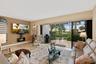 Living area featuring large-format tile flooring, recessed lighting, wall-mounted electric fireplace, and expansive multi-panel sliding glass doors op