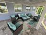 Covered patio featuring concrete paver flooring, stucco exterior walls, multi-pane windows, and a decorative lattice ceiling treatment