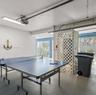 Garage space featuring painted concrete flooring, integrated ceiling-mounted light fixtures, and white lattice partition detailing