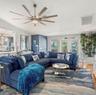 Multi-blade brushed-nickel ceiling fan with integrated center light, glass-paneled double doors, wood-finish flooring, and crisp white trim