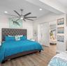 Multi-blade stainless steel ceiling fan with integrated lighting, wood-finish flooring, recessed ceiling lighting, and a neutral color palette
