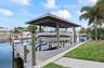 Private dock featuring a wooden deck, covered boat lift, and direct water access