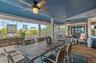 Covered outdoor living area featuring tile flooring, a painted vaulted ceiling, dual ceiling fans, and floor-to-ceiling screened enclosures