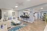 Open-concept interior featuring wood-finish flooring, a kitchen pass-through counter, ceiling fans, and a ductless mini-split system