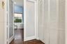 Interior space featuring wood-finish flooring, white louvered bifold closet doors, and a glass-panel door