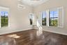 Interior space featuring wood-finish flooring, vaulted ceilings, dual-pane windows with plantation shutters, and a wall-mounted ductless air condition