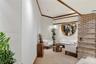 Architectural interior featuring a floor-to-ceiling brick column, circular wall cutout with wood trim, recessed lighting, and crown molding