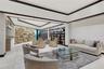 Spacious room featuring a tiered tray ceiling, large-scale stone accent wall, extensive built-in floor-to-ceiling shelving, recessed lighting, and lar