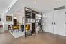 Custom wood-framed decorative partition, large-format tile flooring, recessed ceiling lighting, and double-entry doors