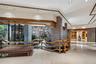 Interior featuring stone masonry pillars, tile flooring, recessed lighting, lattice woodwork accents, and a built-in water feature