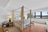 Bedroom featuring expansive floor-to-ceiling windows, neutral carpeting, recessed ceiling lighting, and wall-mounted light fixtures