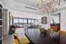 Open-concept interior featuring large-format tile flooring, exposed concrete structural column, floor-to-ceiling glass sliding doors, ornate metal cha