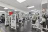 Fitness center featuring rubberized floor tiling, wall-to-wall mirrors, recessed lighting, and a drop ceiling