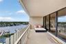 Covered balcony featuring tile flooring, metal railing, and floor-to-ceiling glass sliding doors