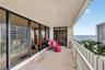 Covered balcony featuring concrete flooring, a white metal picket railing, and extensive floor-to-ceiling glass sliding doors