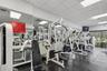 Fitness center featuring modular rubber flooring, full-wall mirrors, recessed drop-ceiling lighting, and floor-to-ceiling windows