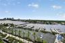 Waterfront property featuring a private marina with multiple boat slips and professional tennis courts surrounded by mature palm trees