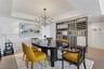 Tray ceiling with recessed lighting, multi-arm metal chandelier, and a custom decorative open-frame metal partition