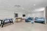 Spacious room featuring neutral large-format tile flooring, textured geometric ceiling panels, and recessed LED lighting