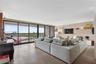 Floor-to-ceiling sliding glass doors, expansive balcony, large-format tile flooring, and built-in wall cabinetry