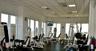 Fitness center featuring floor-to-ceiling windows, drop ceiling with recessed lighting, and rubberized flooring