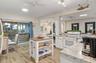 Kitchen featuring white cabinetry, stone-finish countertops, wood-finish flooring, a mobile kitchen island, and a sliding glass door