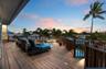 Expansive wood-plank deck featuring a wrap-around railing, integrated low-voltage lighting, and direct water access