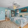 Wood-finish flooring, crystal-accented ceiling fan with integrated lighting, and neutral-toned wall treatments