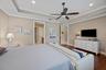 Tray ceiling featuring crown molding, recessed lighting, and ceiling fan with integrated light fixture, complemented by dark wood-finish flooring