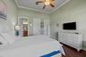 High ceilings featuring crown molding, wood-finish flooring, and a ceiling fan