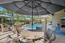 Screened lanai featuring paver flooring, custom pool with built-in spillway, and ceiling fan