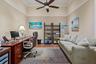 High ceiling featuring crown molding and a central ceiling fan with an integrated light fixture, complemented by wood-finish flooring