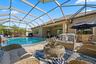 Screened-in patio featuring a swimming pool, stone paver decking, and a covered lanai