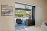Multi-panel sliding glass doors with white plantation shutters, recessed ceiling lighting, and a covered lanai featuring a ceiling fan and screen encl