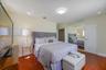 Bedroom featuring wood-finish flooring, full-wall mirrored closet doors, and a ceiling-mounted light fixture