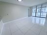 Large-format tile flooring, floor-to-ceiling glass sliding doors, and neutral wall tones