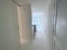 Glossy large-format tile flooring, recessed ceiling lighting, and louvered-panel closet doors