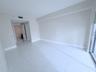 Neutral-toned interior space featuring polished tile flooring, recessed ceiling lighting, and glass sliding doors