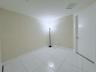 Neutral-toned walls, white large-format tile flooring, and a solid-core interior door with satin nickel hardware