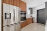 Kitchen featuring wood-finish cabinetry, stainless steel double wall ovens, a matching French-door refrigerator, and terrazzo flooring