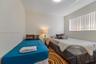 Room featuring wood-finish flooring and a horizontal window with vertical blinds