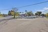 Corner lot property featuring a masonry perimeter wall, integrated metal fencing, and mature landscaping