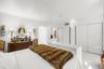 Minimalist interior featuring high-gloss flooring, recessed lighting, and dual floor-to-ceiling closets with sliding doors