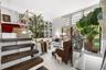 Floor-to-ceiling built-in library shelving with rolling ladder, high-gloss tile flooring, dark wood-finish open staircase, floor-to-ceiling windows wi