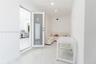 Interior space featuring polished white tile flooring, a frosted glass-panel door, and a white beadboard ceiling with recessed lighting